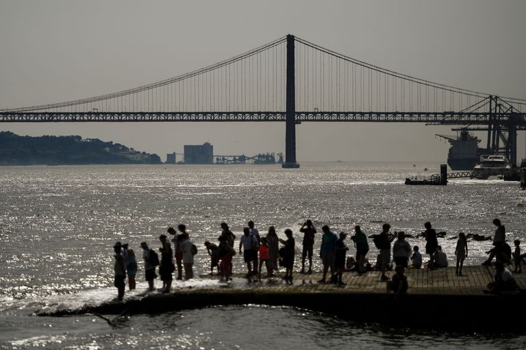 Inimesed otsivad Lissabonis jahutust Tejo jõe ääres.