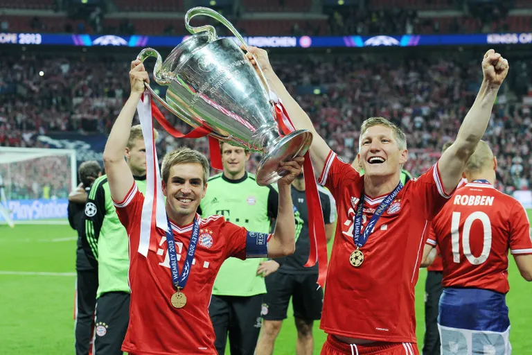Philipp Lahm (vasakul) ja Bastian Schweinsteiger 2013. aasta Meistrite liiga trofeega.