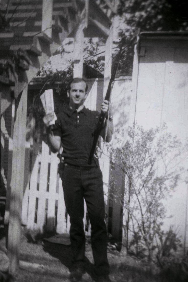 Lee Harvey Oswald tagaaias, ühes käes vintpüss, teises kommunistlik ajaleht.