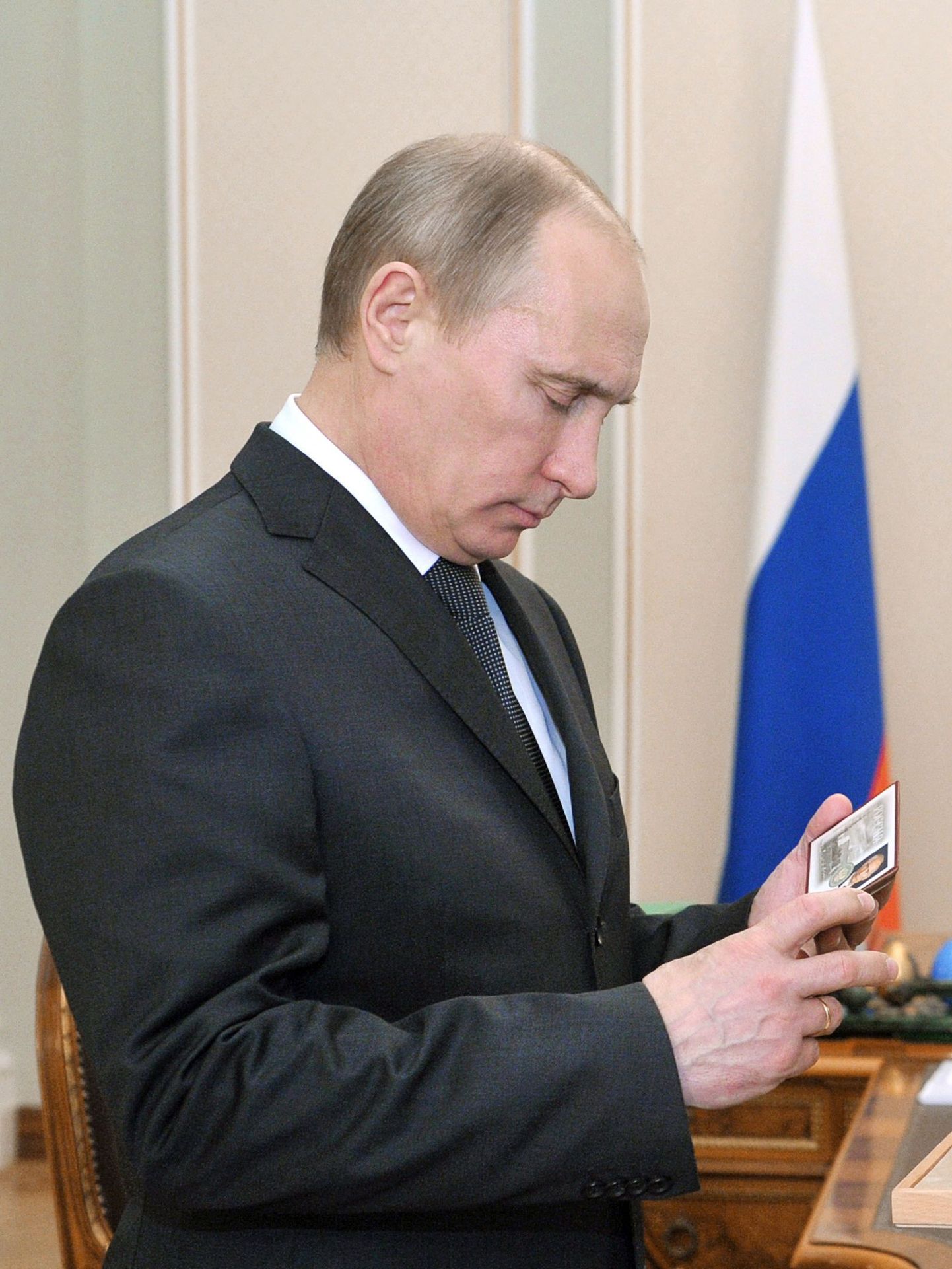 Vladimir Putin uurib oma uut ametitunnistust.