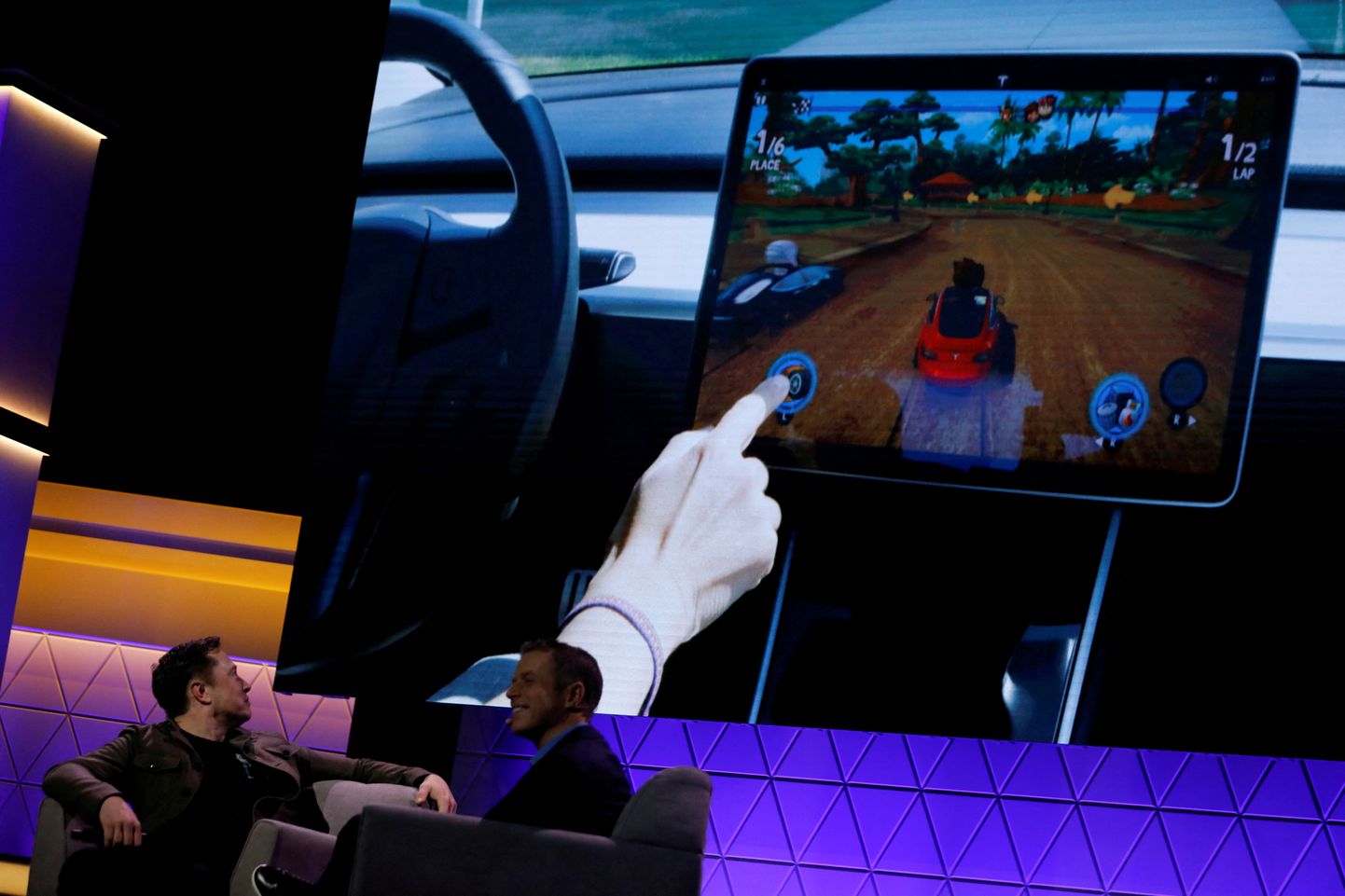 Tesla tegevjuht vaatab videoklippi Elon Musk, kuidas Tesla Model 3 ekraanil arvutimängu mängitakse, vesteldes mängudisainer Todd Howardiga E3 konverentsil Los Angeleses 2019. aastal.