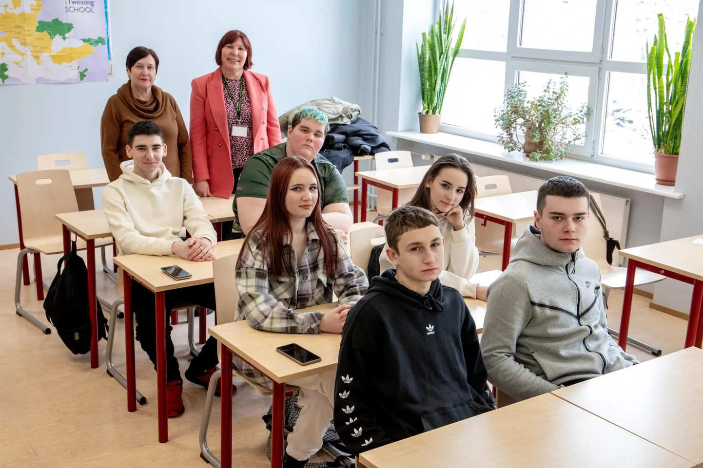 Молодые украинцы, изучающие гостиничный менеджмент по программе Пярнумааского центра профессионального образования, улыбаются во время фотосессии, но преподаватели Малле Каллус (на заднем плане слева) и Майе Есютина слышали их трагические истории.