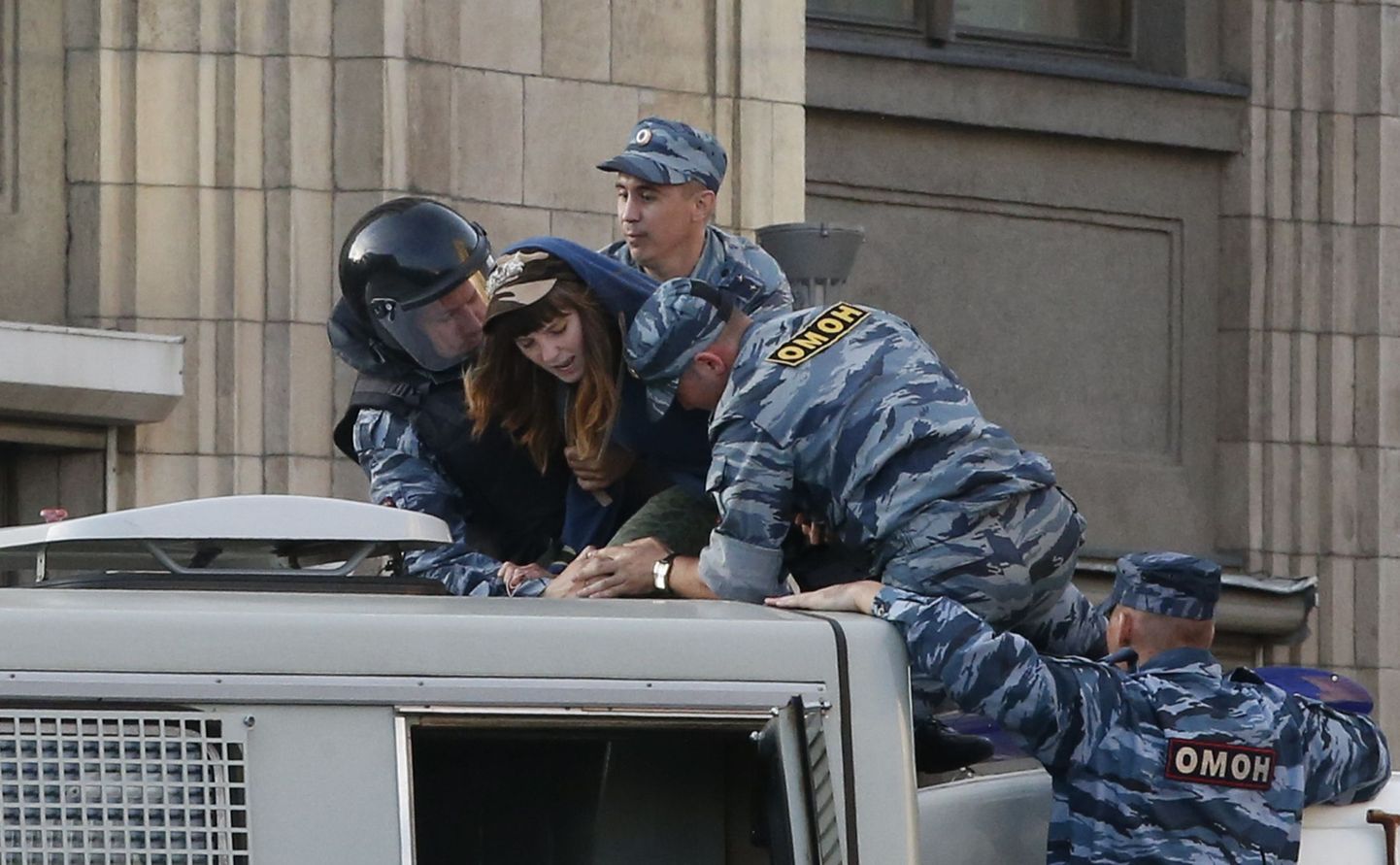 Politsenikud eile Kirovi kohtuhoone lähedal üritamas protestijat politseiautosse suruda.