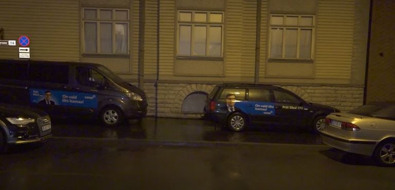 Две машины с рекламой «Отечества», припаркованные на тротуаре. 