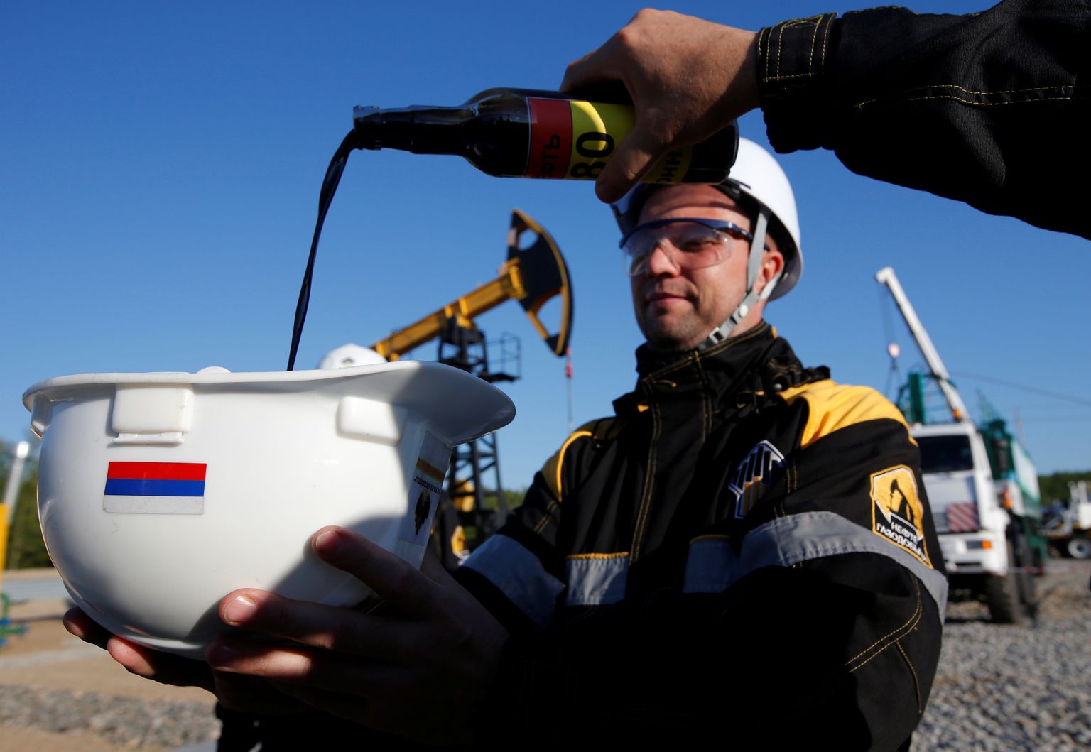 Töölised näitamas naftaproovi Rosnefti Priobskoje maardla aladel Neftejuganski linna rafineerimistehases 4. augustil 2016.