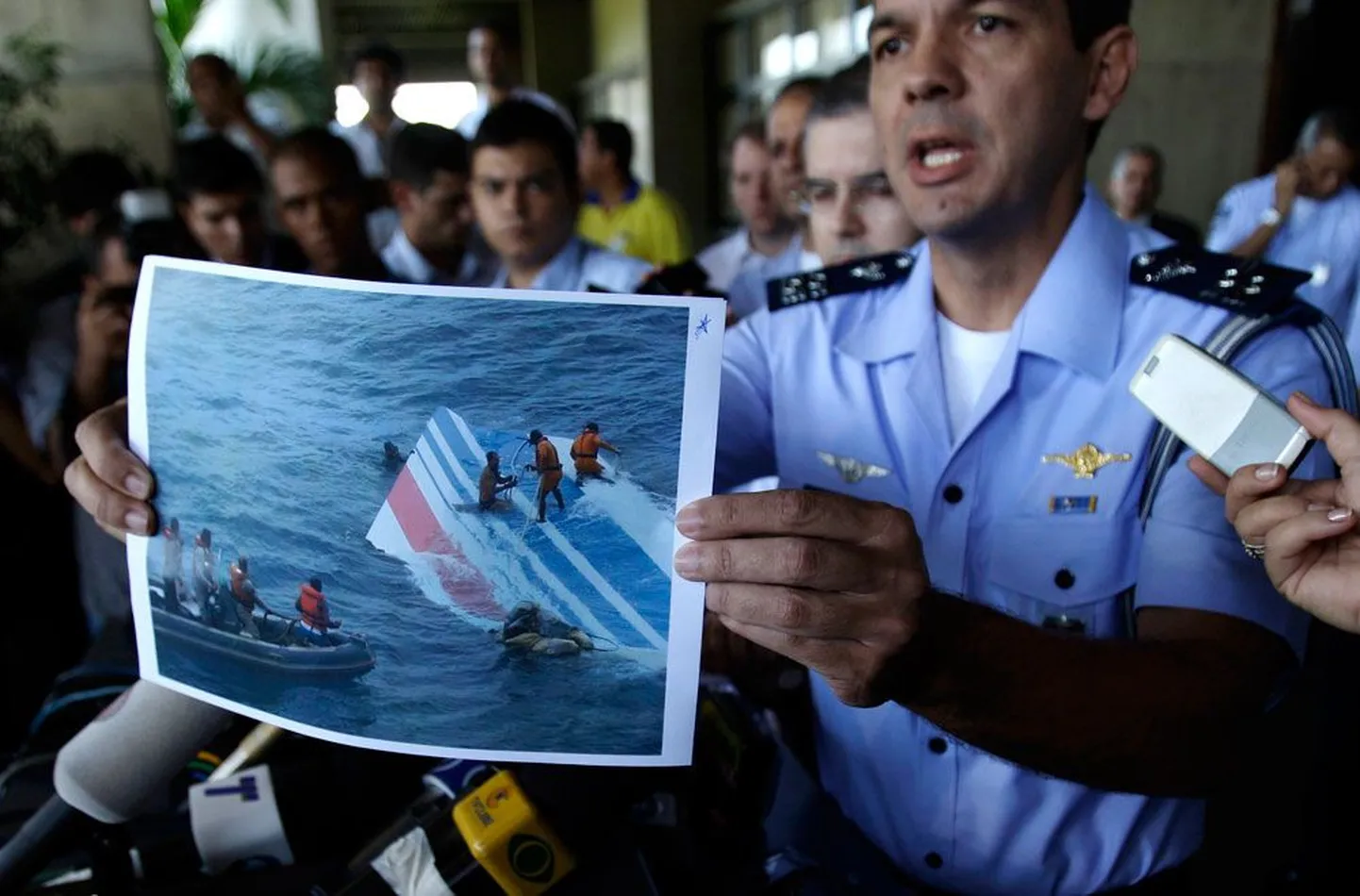 Представитель ВВС Бразилии Энри Мундуж на пресс-конференции показывает фотографии, где изображено, как из океана достают кусок    хвоста пропавшего самолета Airbus.