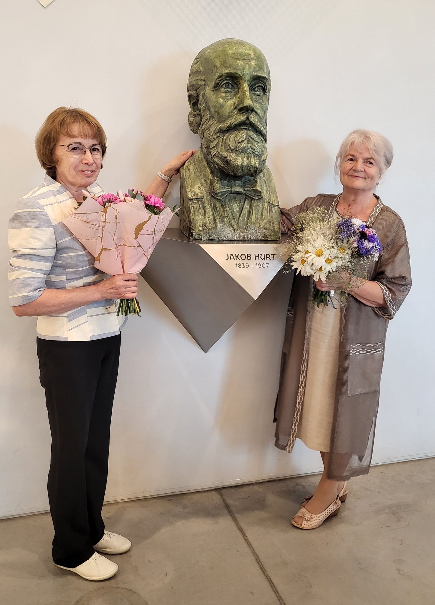 32. Jakob Hurda rahvuskultuuri auhinna laureaadid Ellen Värv (vasakul) ja Urve Järg seismas Hurda kujuga Eesti Rahva Muuseumis.
