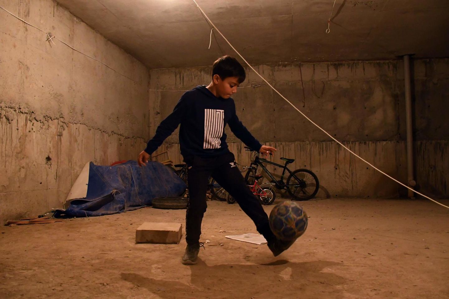 Armeenlasest poiss harjutamas Stephanakerdi kortermaja keldrisse rajatud varjendis jalgpalliga žonglöörimist.