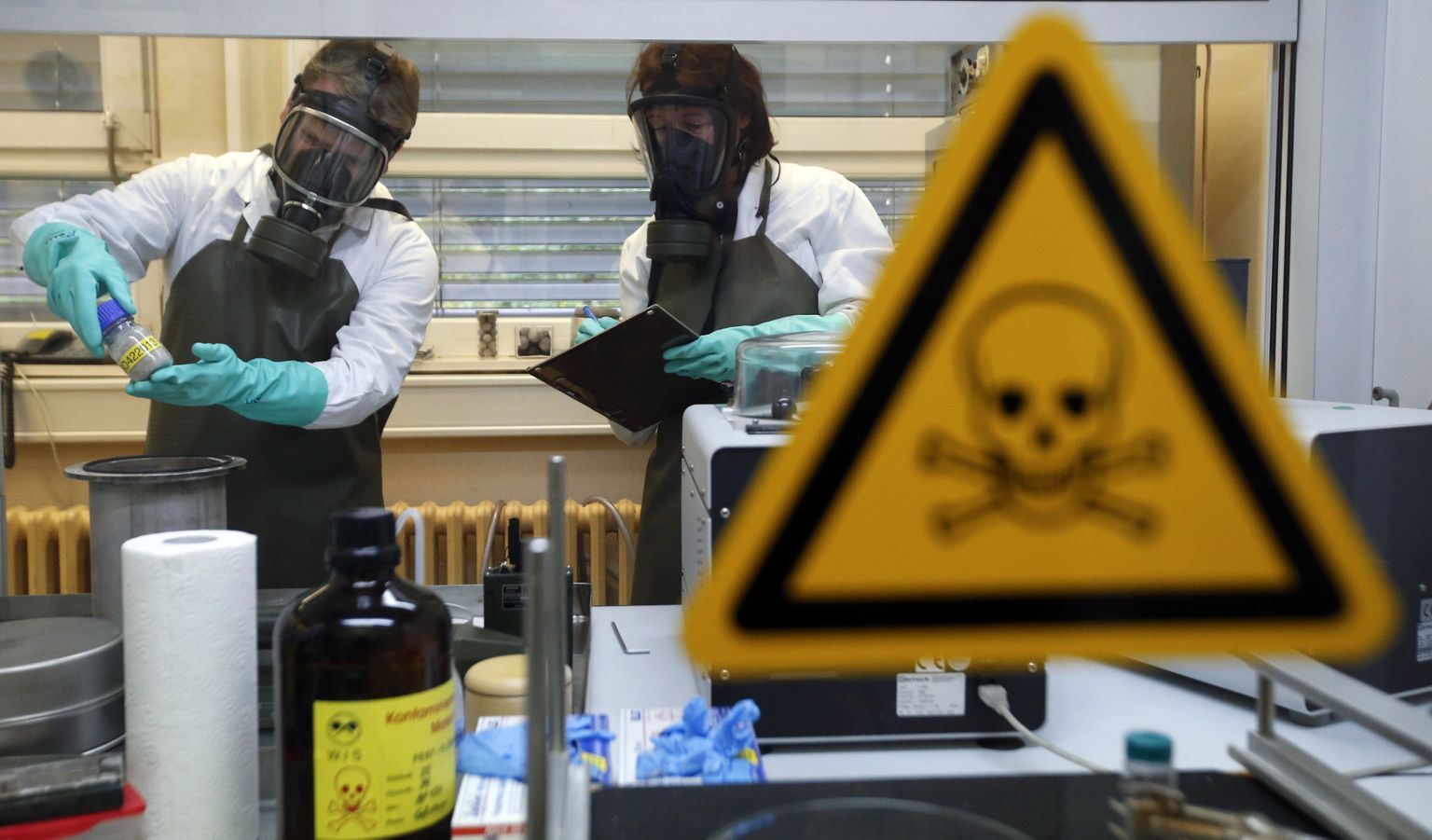 Сотрудники Научно-исследовательского института защитных технологий, ядерной, биологической и химической защиты (WIS) осматривают загрязненный образец. WIS - лаборатория Организации по запрещению химического оружия (ОЗХО).