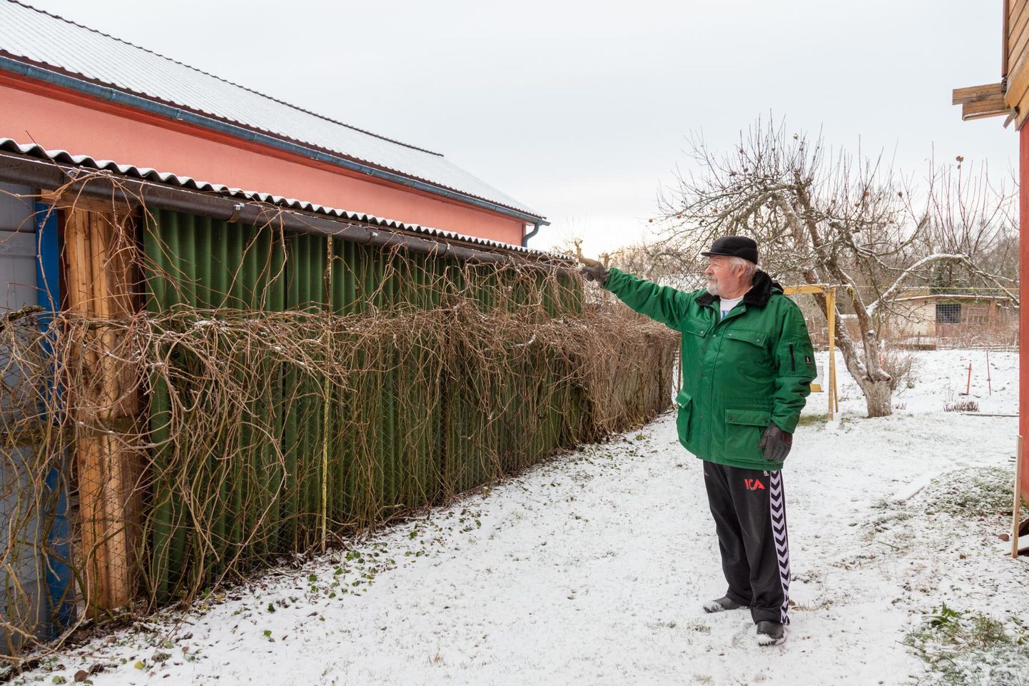 Pinska küla elanik Aleksander Razumov näitab vastu oma krunti ehitatud varjualust, mille katuselt sulavesi otse tema maale tuleb.