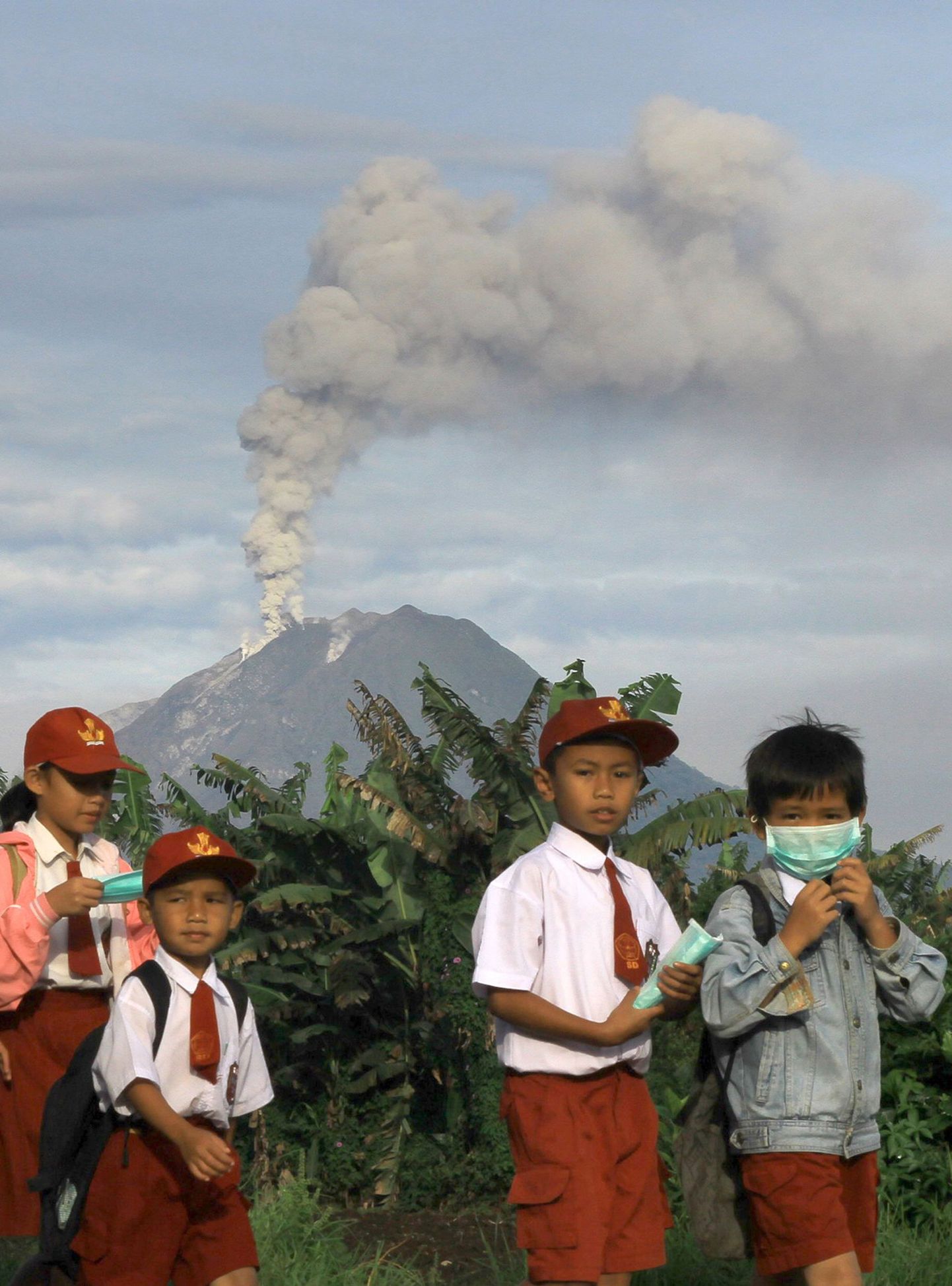 Indoneesia koolilapsed Sinabungi vulkaani taustal