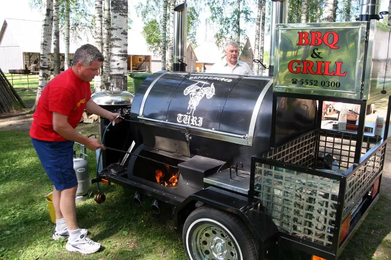 Arvi Pitelkov lisab puid, et 36kilogrammine siga Türi Pritsumeeste uues haagisahjus korralikult valmis küpseks.
