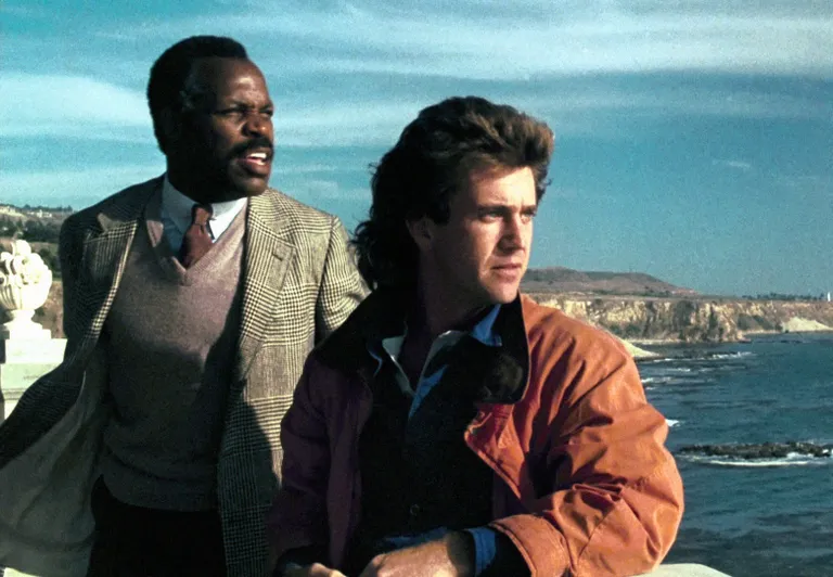 Danny Glover ja Mel Gibson 1987. aasta filmis «Surmarelv». Selle ja järgneva kolme «Surmarelva» filmi režissöör oli ei keegi muu kui Richard Donner.
