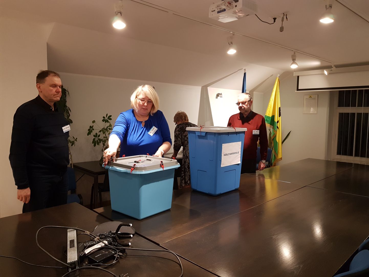 Järva-Jaani valimisjaoskonna esimees Kaja Reinberg (keskel) avab valimiskasti, millest leiab ka valla hooldekodude elanike hääled.