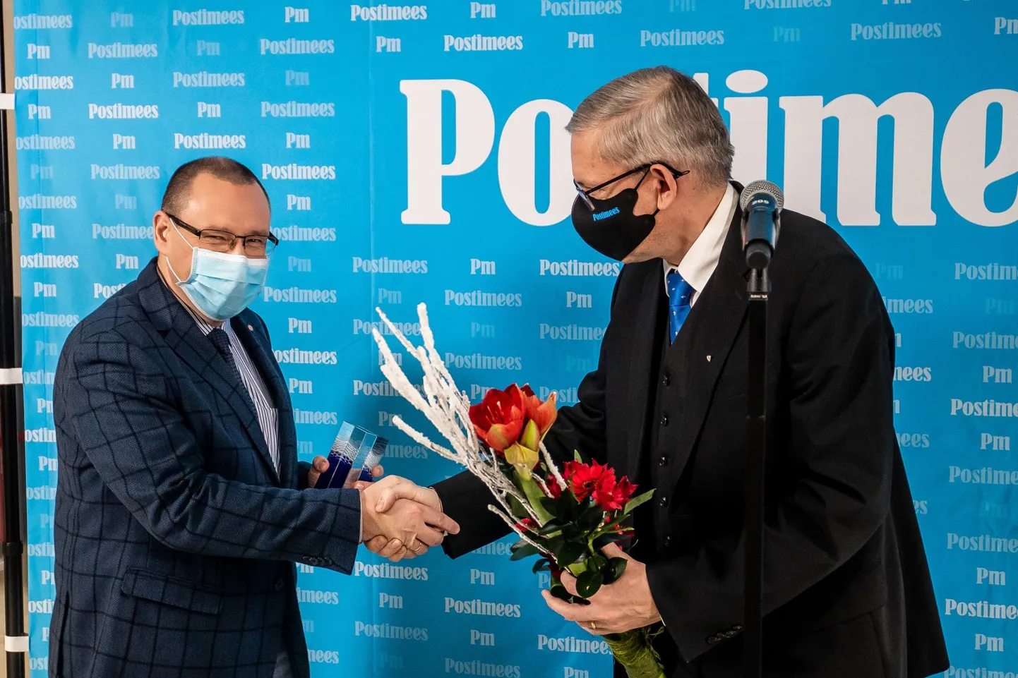 Postimehe peatoimetaja Mart Raudsaar annab Arkadi Popovile aasta inimese tiitliga kaasnevat meene.