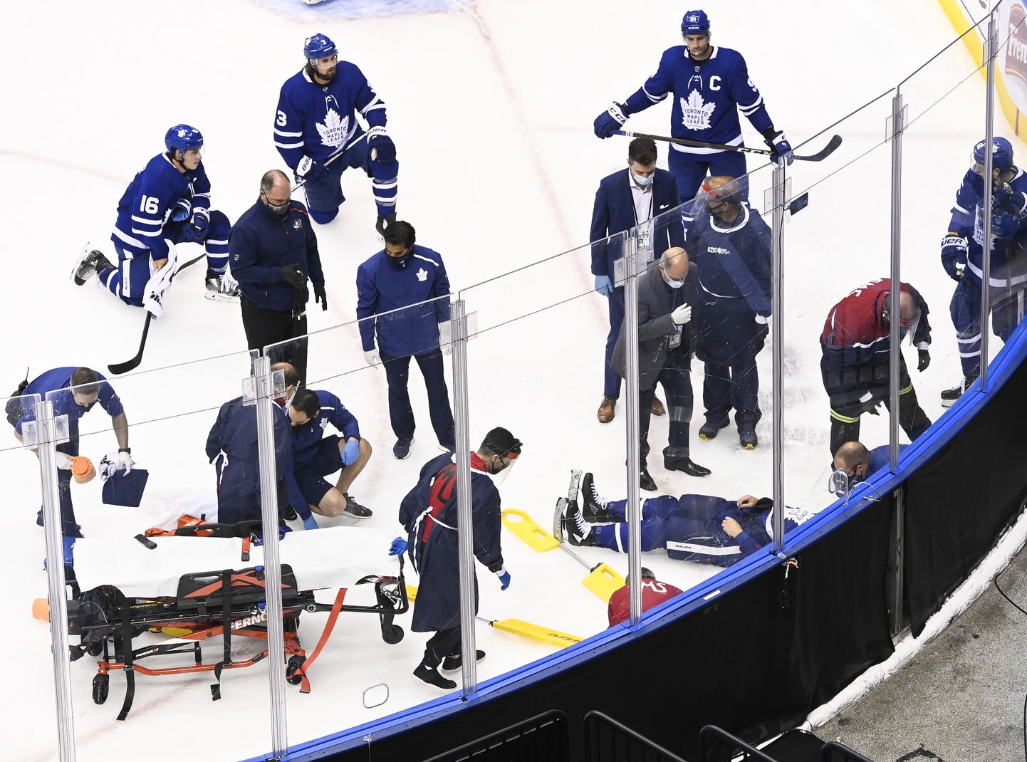 Jäähokiklubi Toronto Maple Leafsi mängijad ja meditsiinitöötajad viga saanud meeskonnakaaslase Jake Muzzini ümber.