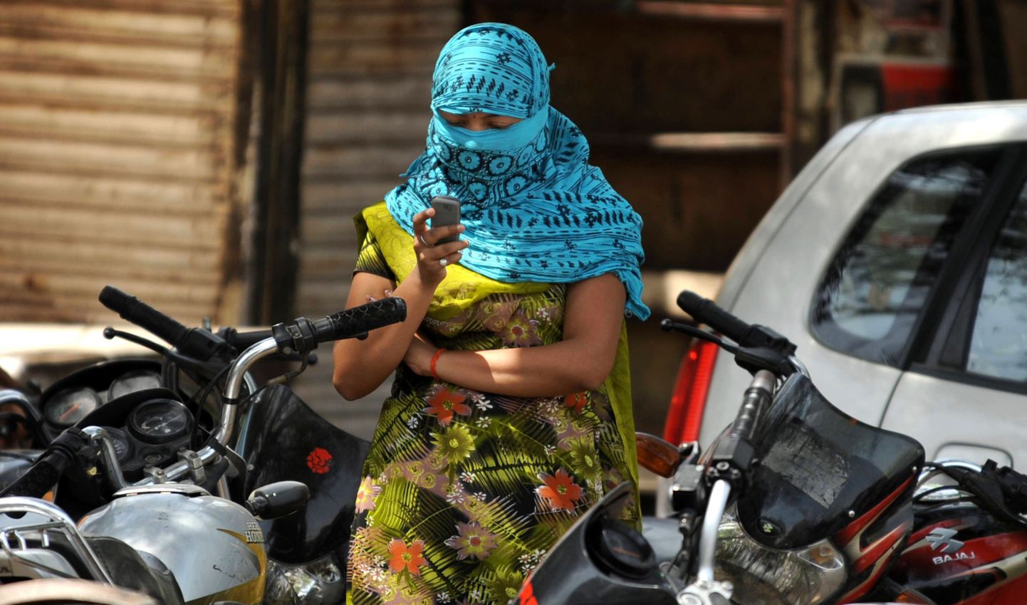 India naine nautimas telefonikasutamise võimalust.