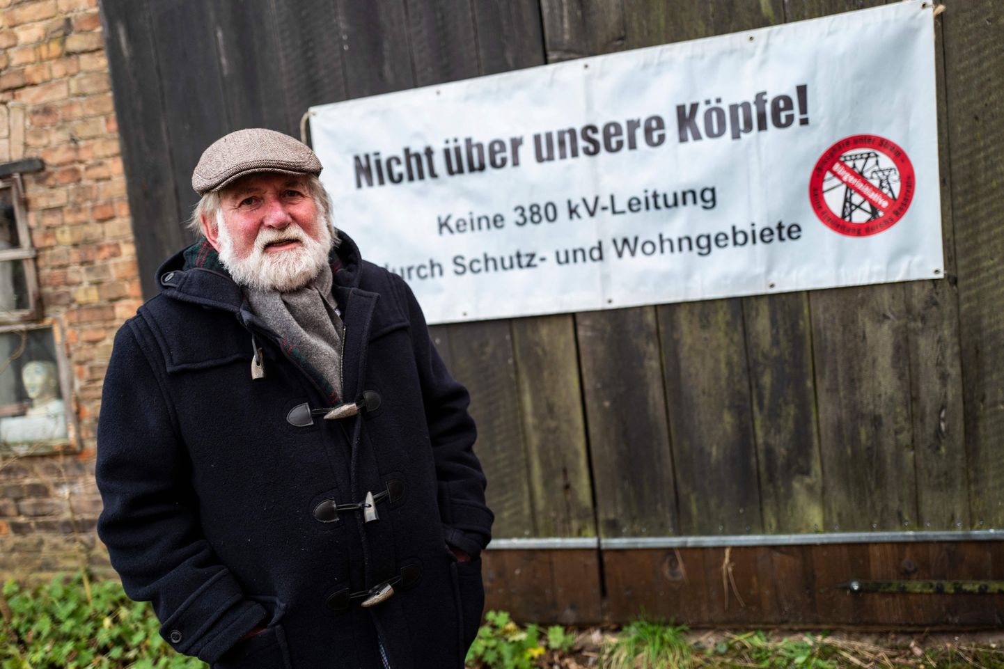 Keskkonnakaitsja Hartmut Lindner poseerib oma tagahoovis Senftenhüttes Brandenburgi liidumaal plakati ees, mille on kiri «Mitte üle meie peade! Ei 380 kV liinile kaitsealustes ja linnapiirkondades».