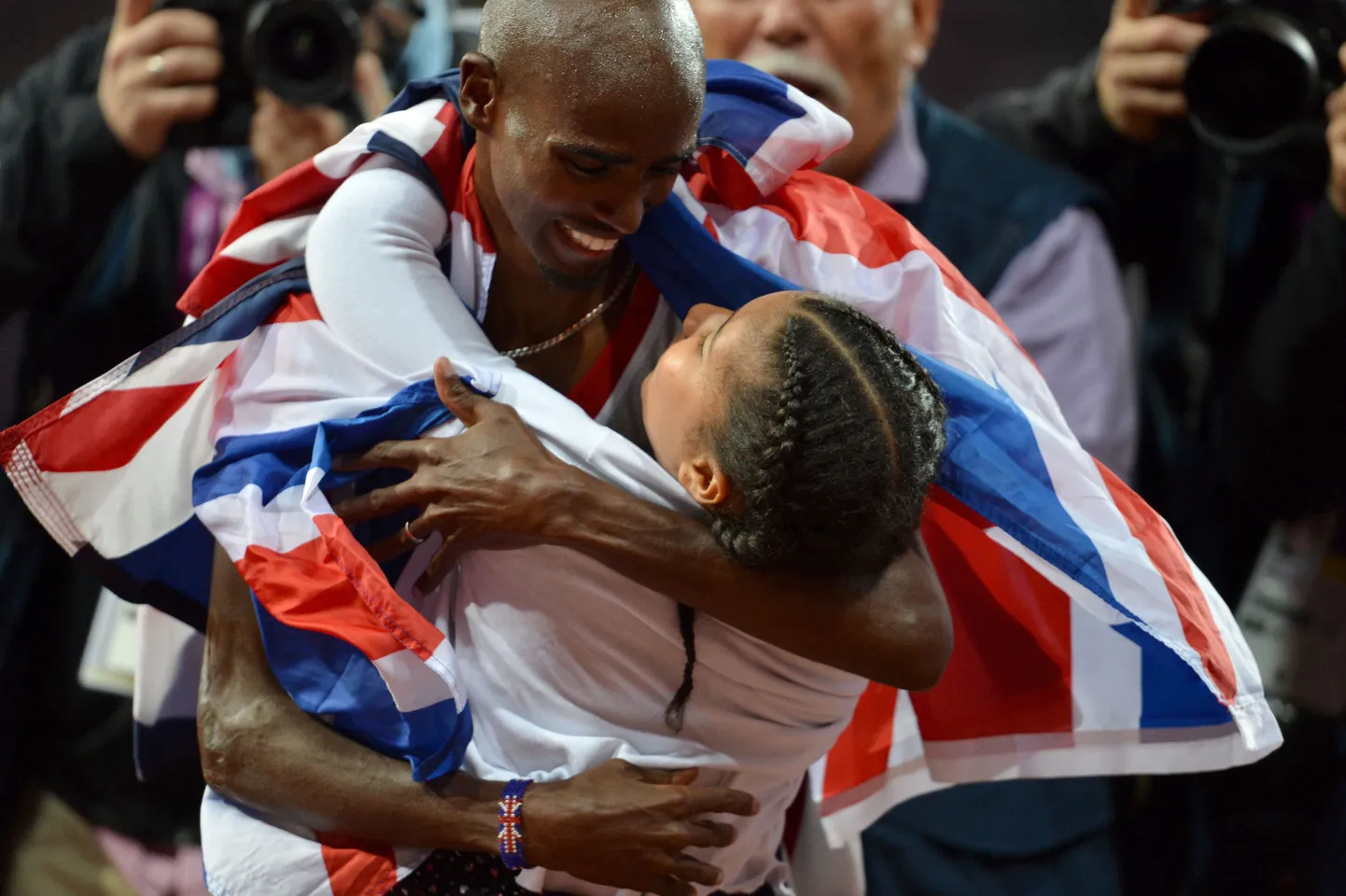 Britain's Mohamed Farah celebrates with his daughter Rihanna after winning the men's 10,000m final at the athletics event of the London 2012 Olympic Games on August 4, 2012 in London.  AFP PHOTO / ERIC FEFERBERG