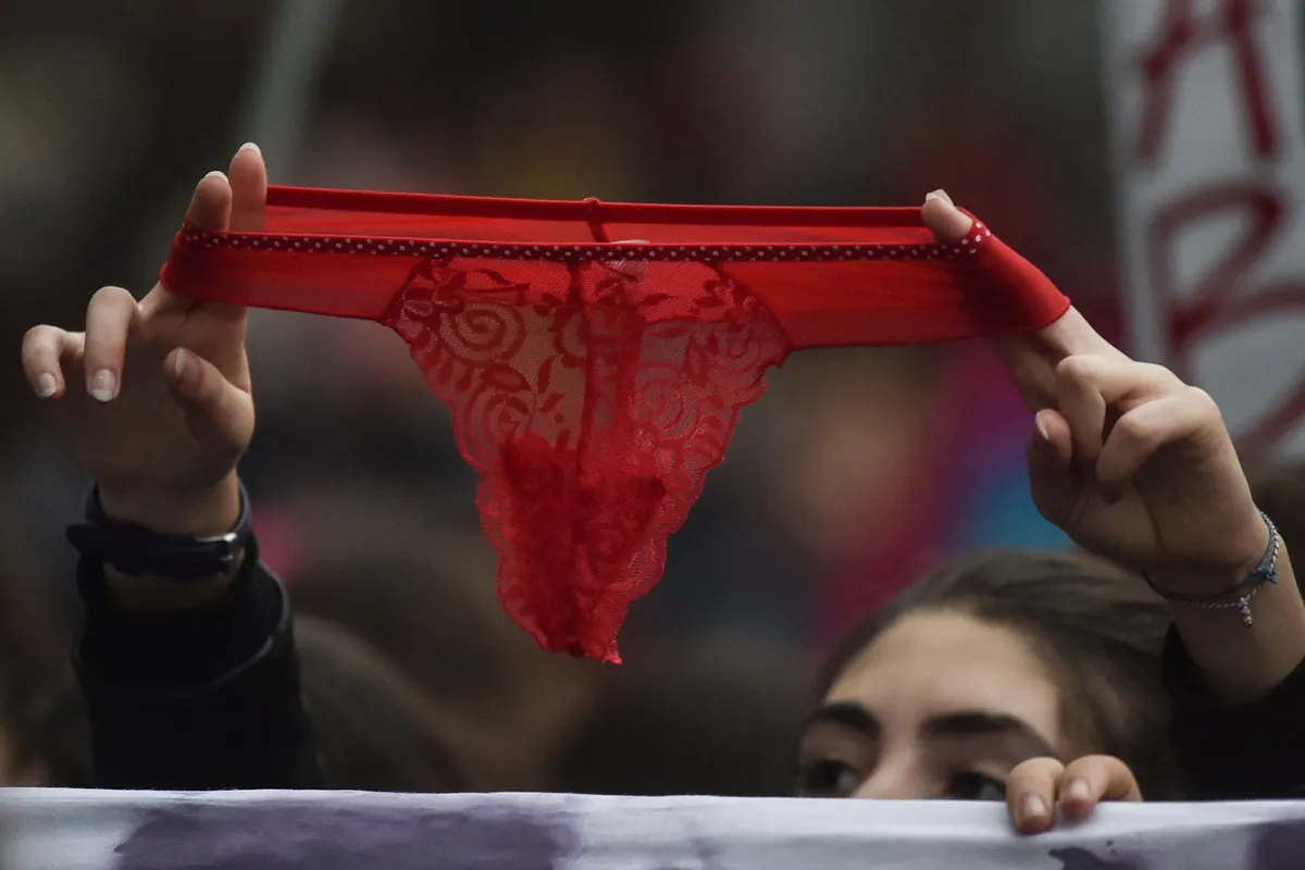 2018. gada 24. novembris, Roma, Itālija. Rādot sarkanas mežģīņu apakšbikses, sieviete pauž atbalstu demonstrācijā pret seksuālu vardarbību pret sievietēm.