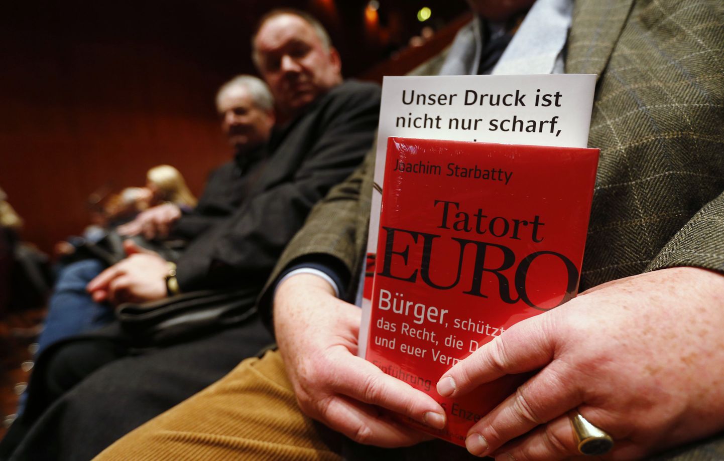 Eurovastase erakonna Alternatiiv Saksamaale toetaja eilsel kohtumisel hoidmas käes raamatut pealkirjaga «Kuriteopaik euro».