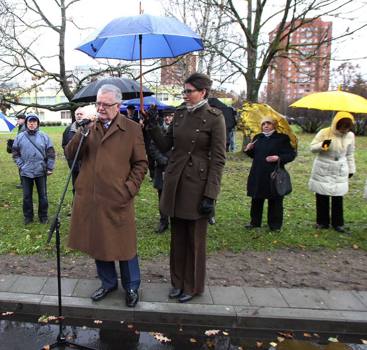 Linnapea Edgar Savisaar kõneleb, vihmavarju hoiab Lasnamäe linnaosavanem Olga Ivanova.