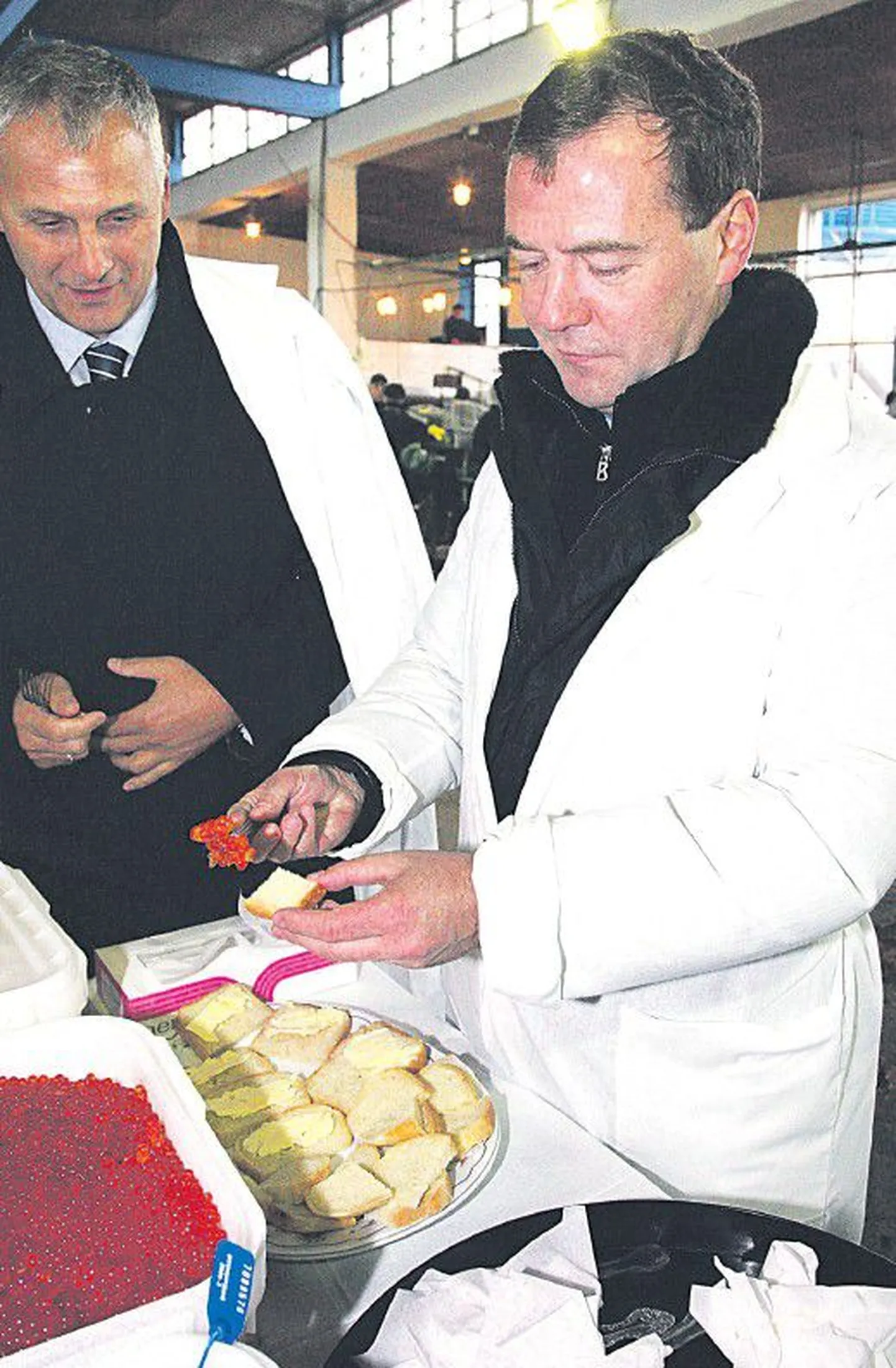 Дмитрий Медведев (справа), прилетев на остров Кунашир, посетил вместе с губернатором Сахалинской области Александром Хорошавиным рыбокомбинат, где их угощали красной икрой.