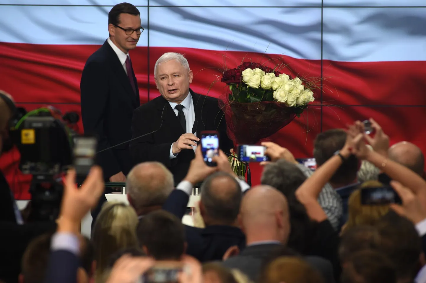 Õiguse ja Õigluse (PiS) esimees Jarosław Kaczynski ja peaminister Mateusz Morawiecki (tagaplaanil) tähistamas üleeile hilisõhtul võitu Poola parlamendivalimistel.