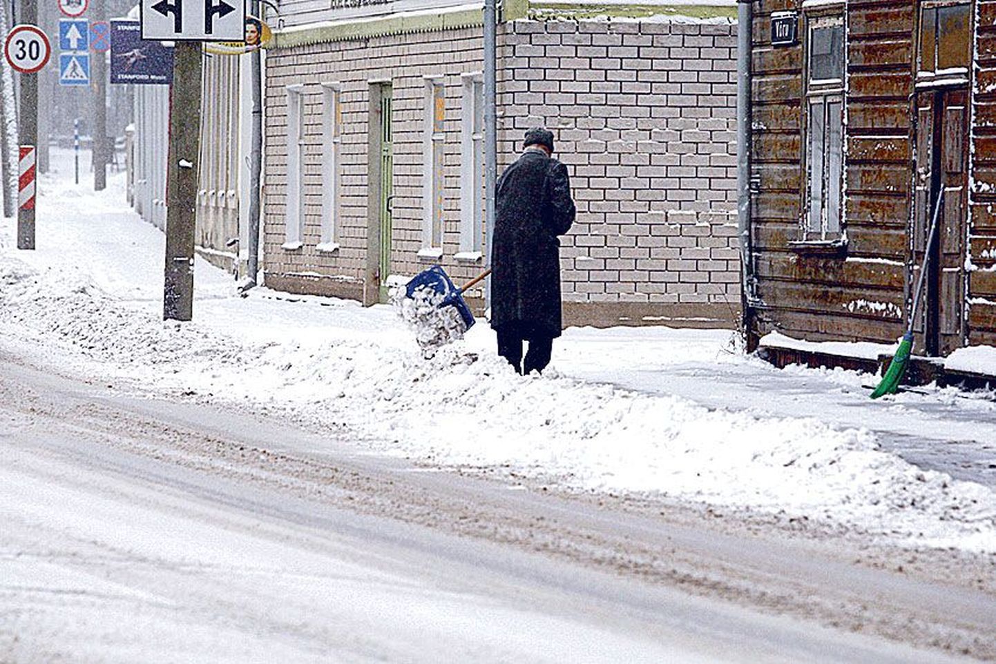 Värske lumi ja tavaline vaatepilt: Võru tänava elanik loopimas lund sõiduteele.