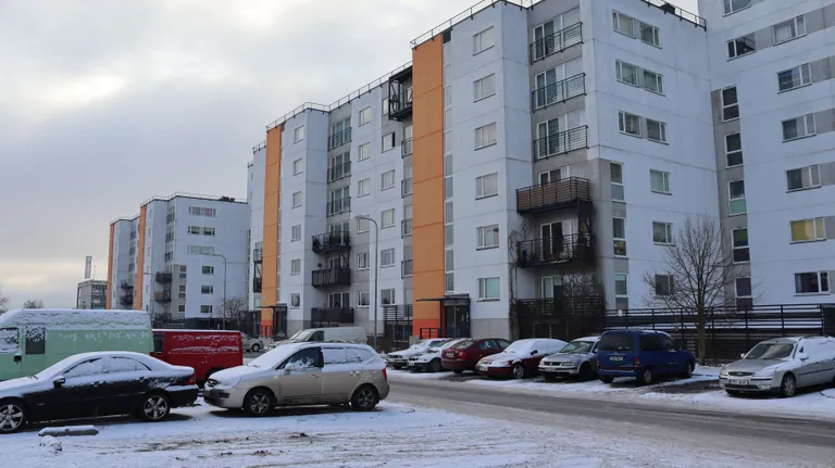 Автомобили разных марок припаркованы перед многоквартирными домами на Раадику. Среди них также машины марок Audi и BMW.