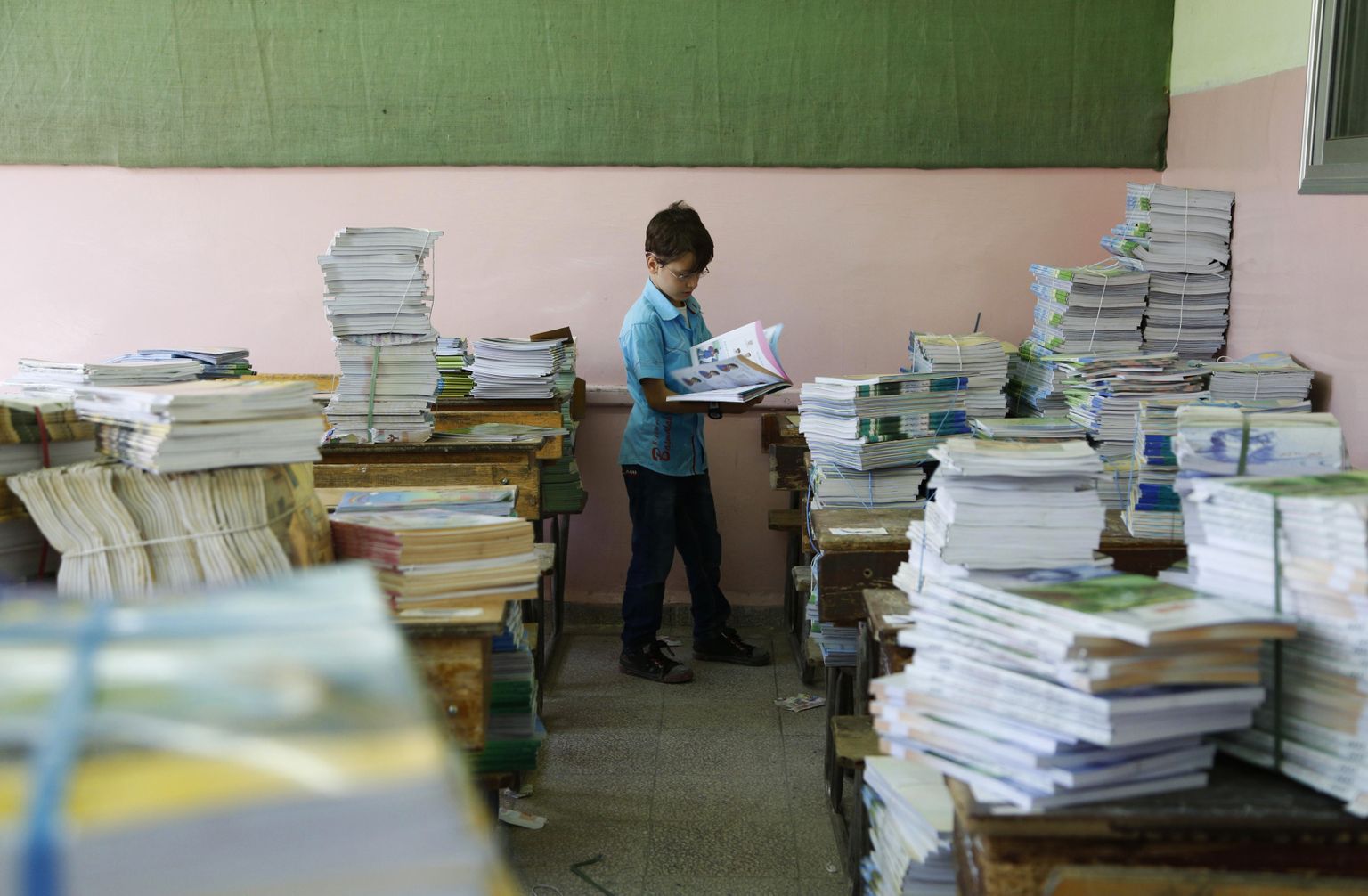 Laps Süüria koolimajas raamatuid uurimas.
