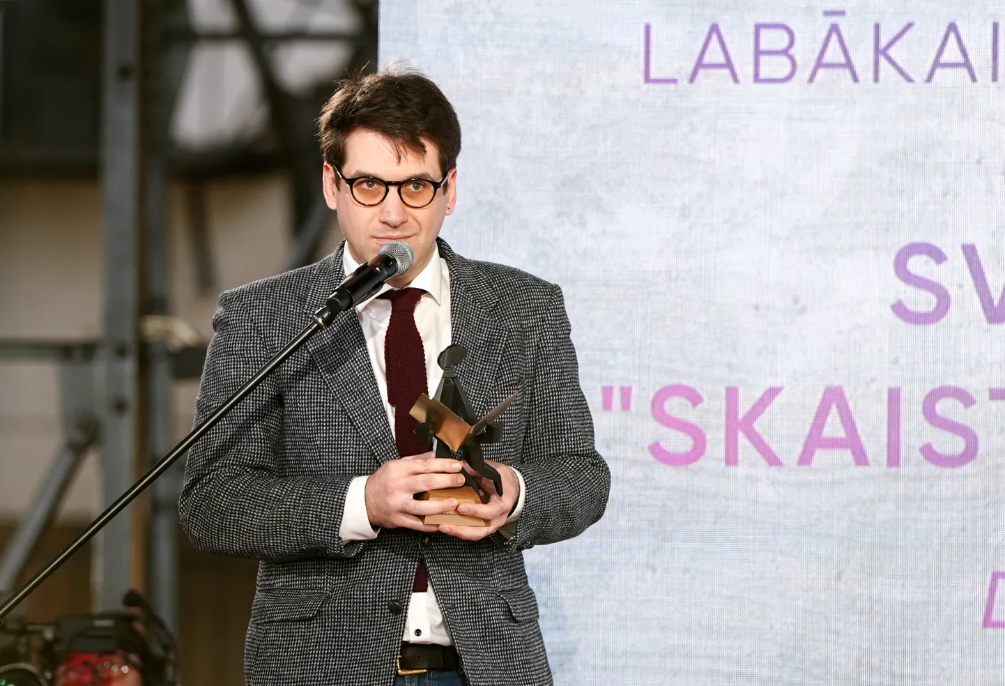 Rakstnieks Svens Kuzmins ar saņemto Literatūras gada balvu nominācijā "Labākais prozas autordarbs" par romānu "Skaistums un nemiers" balvas pasniegšanas ceremonijas laikā Āgenskalna tirgū. 2024. gada 30. aprīlis.