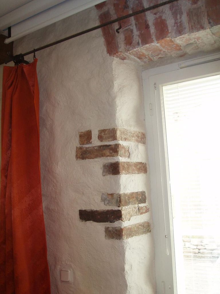 Внешняя стена дома, как выяснилось, сложена из красного кирпича. Поэтому довольно логично оставить несколько старинных кирпичей на виду.
