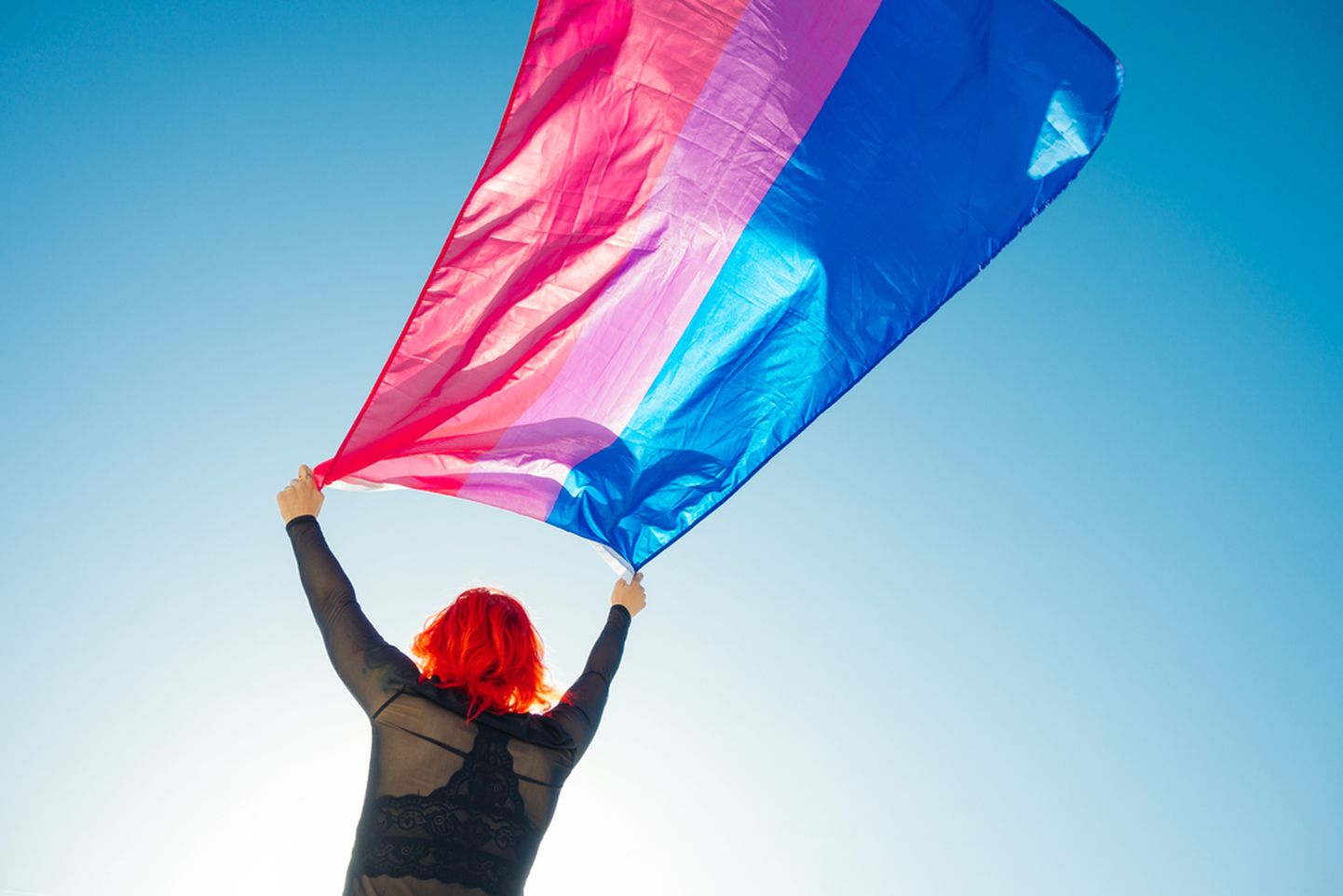 Naine lehviva biseksuaalsust tähistava lipuga.