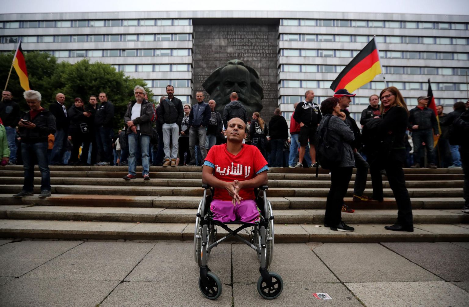 Pärast seda, kui mullu augusti lõpus tapeti väidetavalt välismaalaste poolt sakslane Daniel Hillig, puhkesid Chemnitzis ulatuslikud paremäärmuslaste meeleavaldused, mille peakorraldajaks oli rühmitus Pro Chemnitz. Ratastoolis äärmuslaste keskele tulnud iraaklane Mustafa kandis särki kirjaga «Ei natsidele», avaldades nõnda vastumeelsust välismaalaste vastu suunatud vihale.