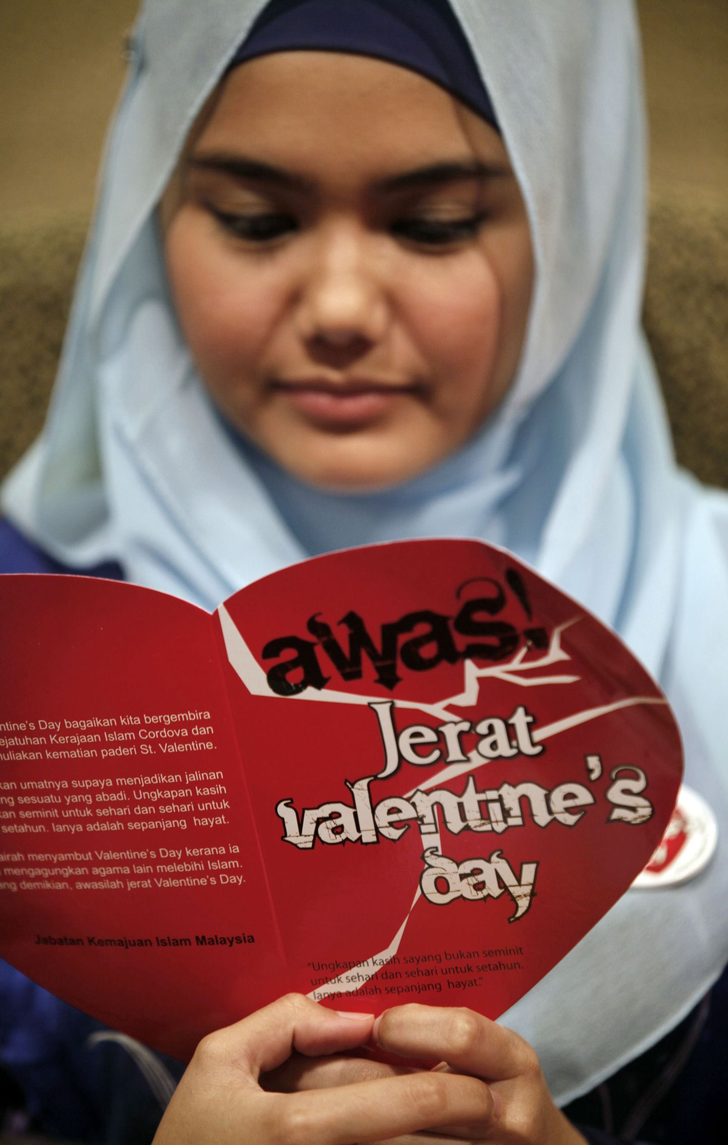 Malaisia moslem Aimi Latif palvetamas valentinipäeva vastasel üritusel. Plakatil seisab: "Ole ettevaatlik valentinipäeva lõksu suhtes."