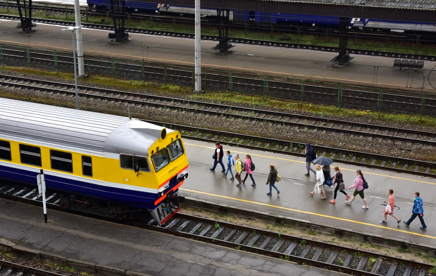 Elektriskais vilciens un cilvēki Rīgas Centrālajā dzelzceļa stacijā.