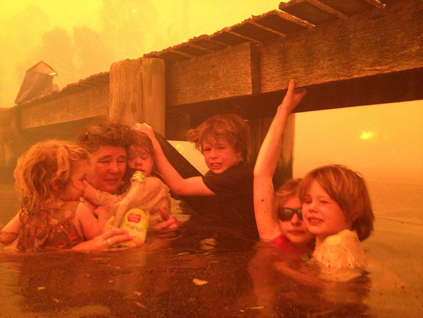 Фото из семейного архива Холмс: Тамми Холмс и ее внуки Шарлот (2 года), Эстер (4 года), Лиам (9 лет), Матильда (11 лет) и Калеб (6 лет) спасаются от пожара в море.