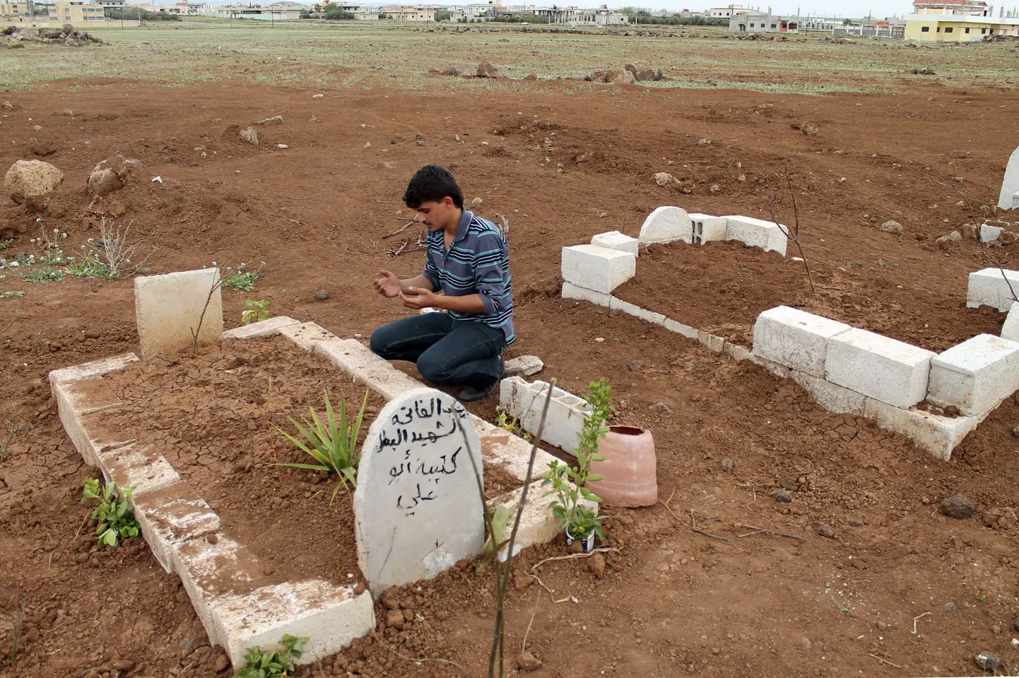 Mees Deraa linnas palvetamas Vaba Süüria Armee võitleja haua juures.