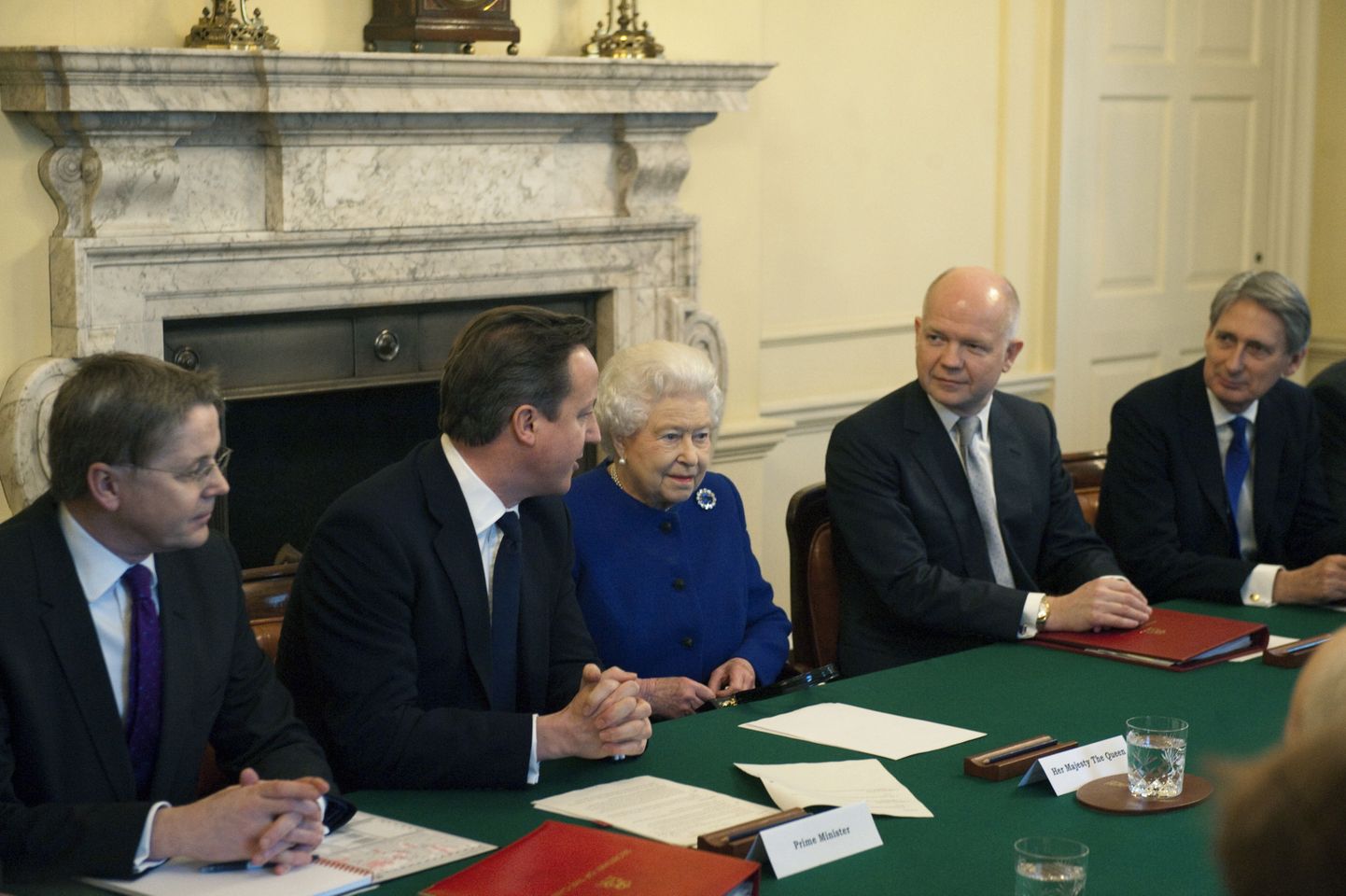 Kuninganna Elizabeth II kuulab peaministri David Cameroni juttu. Kroonitud pea vasakul käel istub välisminister William Hague.