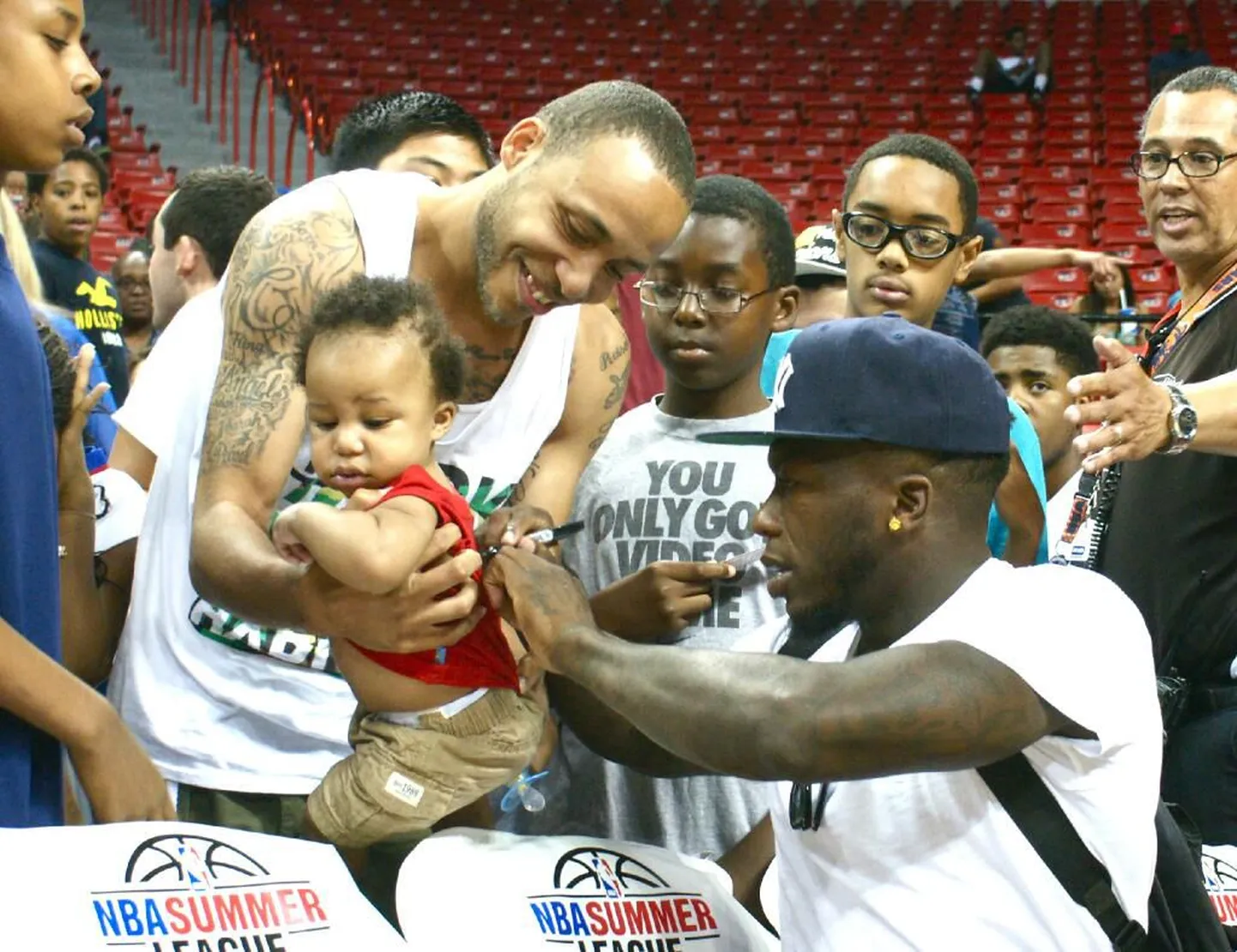 Nate Robinson fänni lapsele autogrammi kirjutamas.
