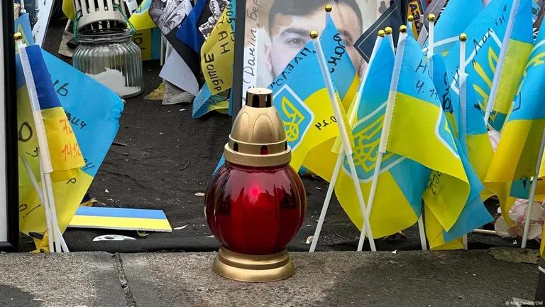 Флажки в цветах государственного флага и свечи в память об украинских военных, погибших на войне