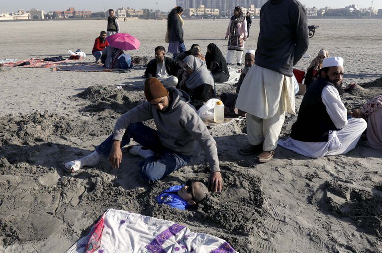 Pakistanis matsid haiguste all kannatavad inimesed end päikesevarjutuse ajaks liiva.