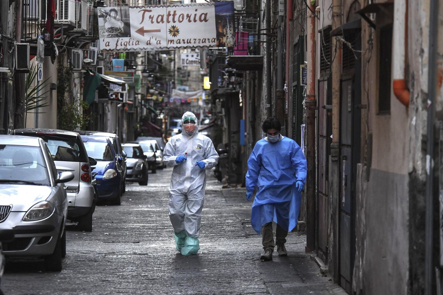Kaitseriietes meditsiinitöötajad inimtühjal tänaval Napolis.