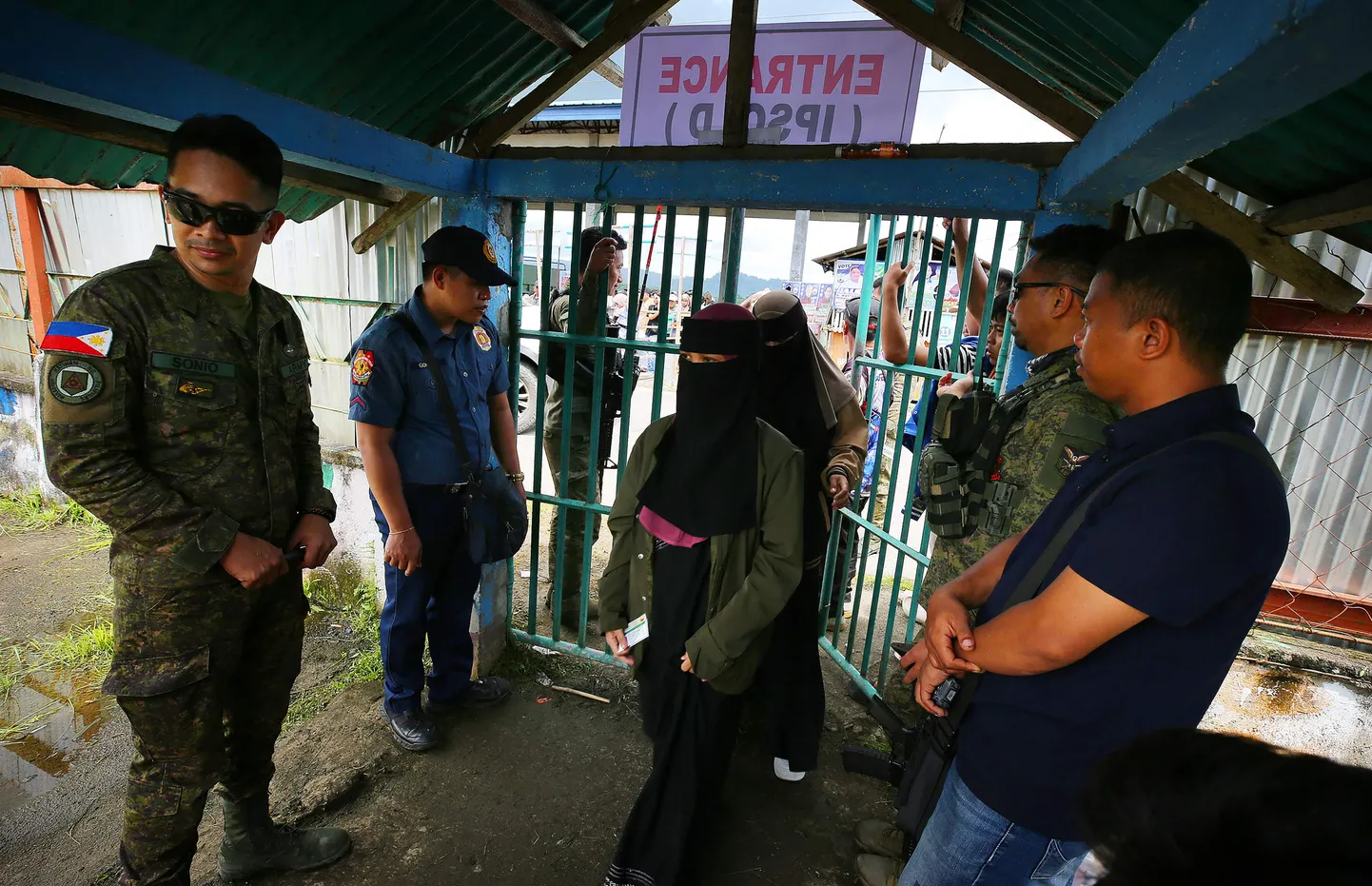Politsei ja sõjaväelased kontrollisid valimisjaoskondades hääletama tulnuid. Foto on tehtud Buadiposo linnas Lanao del Suri provintsis riigi lõunaosas asuval Mindanao  saarel. Esmaspäeval, 12. mail peeti Filipiinidel üleriigilisi vahevalimisi ja mitmeid muid valimisi, sealhulgas linnapeavalimisi. Miljonid filipiinlased osalesid valimistel, milles nähakse omamoodi referendumit ühiskonda lõhestavas tülis president Ferdinand Marcose ja kohtu alla antud asepresidendi Sara Duterte vahel.