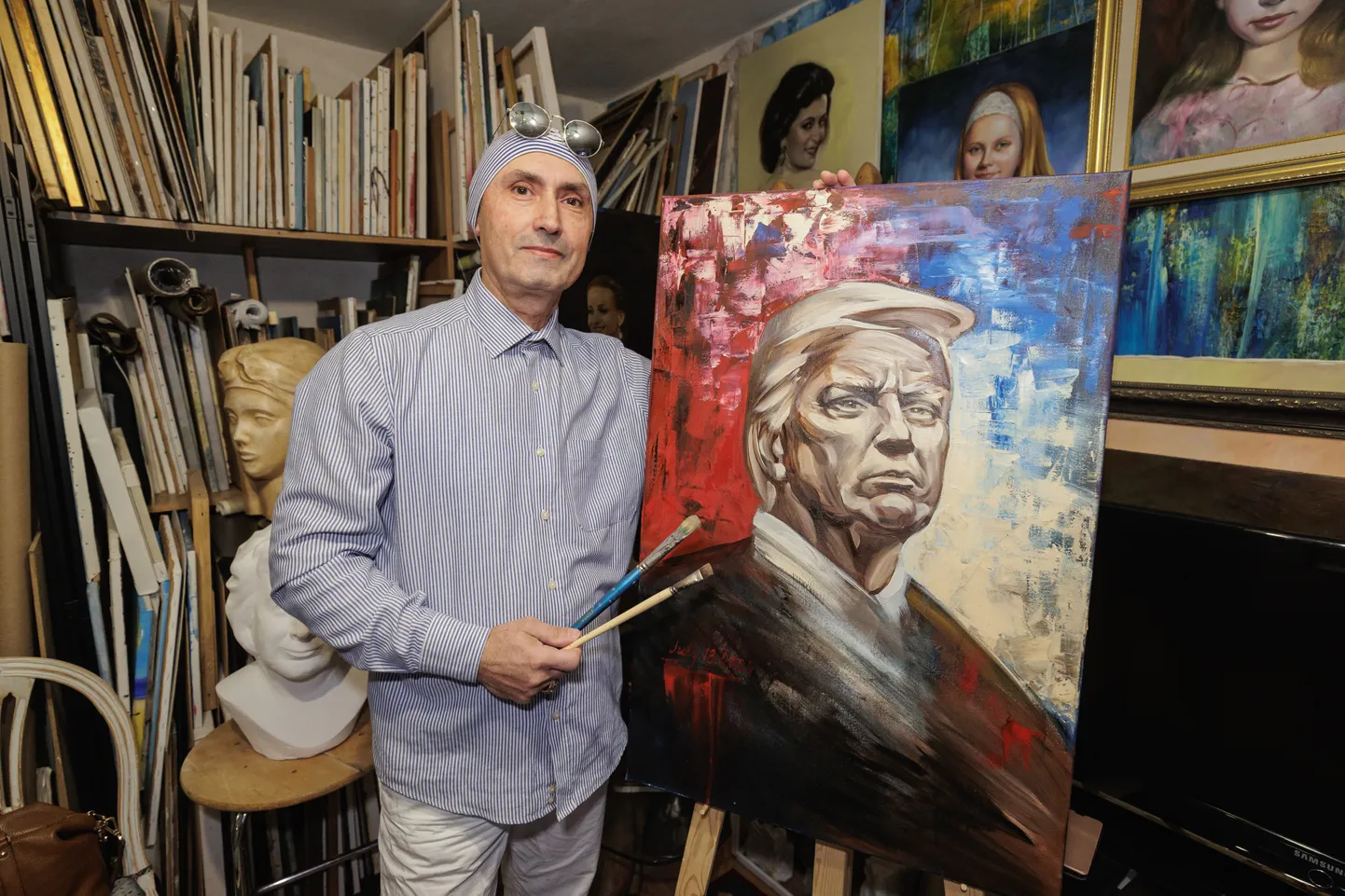 Художник Арсен Клян демонстрирует портрет Трампа.