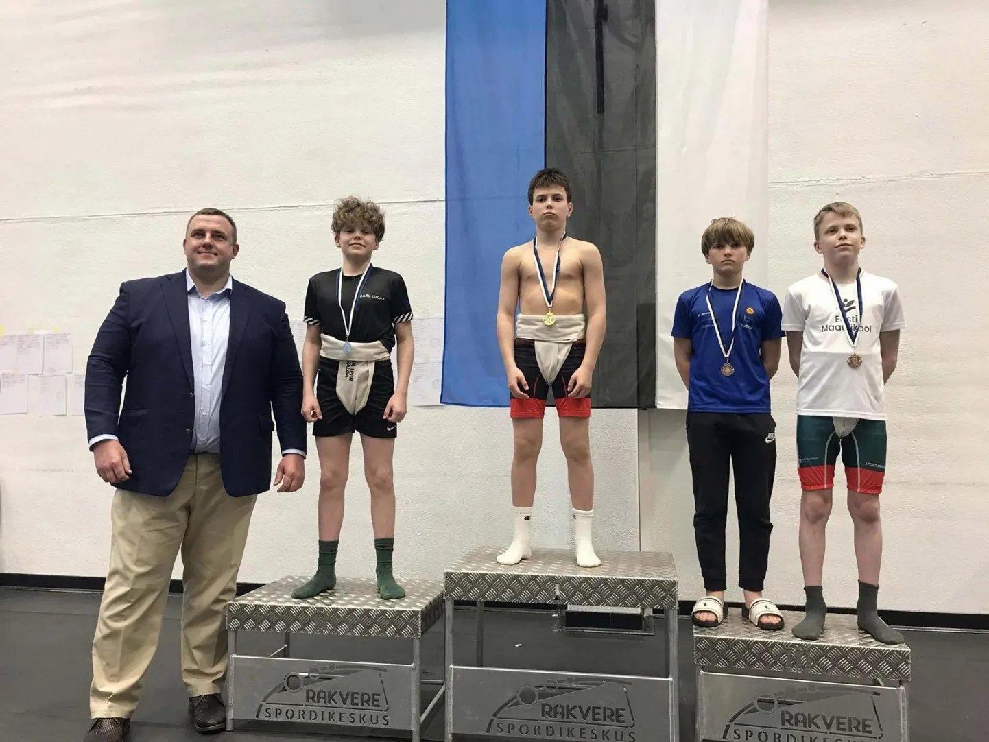 Sumoliidu president Kaido Höövelson (vasakul) ja U15 vanuseklassis kuni 45 kg kategoorias Eesti meistritiitli võitnud Gleb Galat (keskel).
