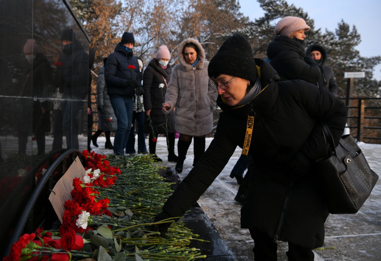 Люди несут цветы в память о погибших в кузбасской шахте.