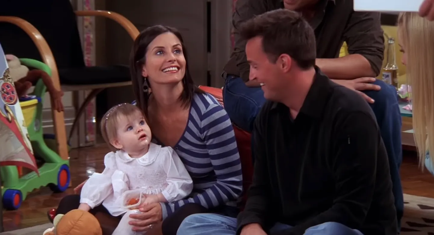 Kuvatõmmis videost: Emma Geller-Green ja Monica Geller (Courtney Cox)  ja Chandler Bing (Matthew Perry).