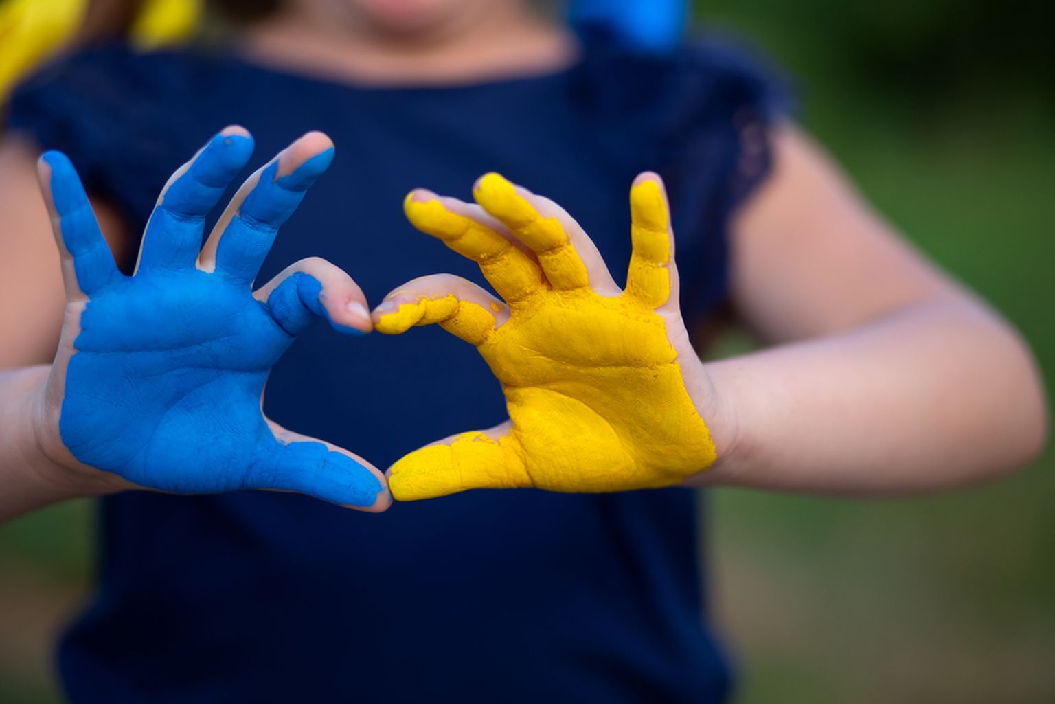 Bērna rokas Ukrainas karoga krāsās.